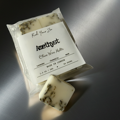 Olive wax melt package with a single melt on a reflective surface