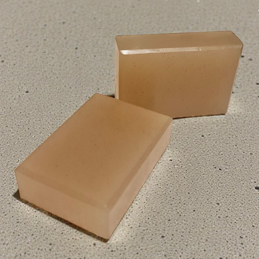 Two beige rectangular soaps on a textured grey surface