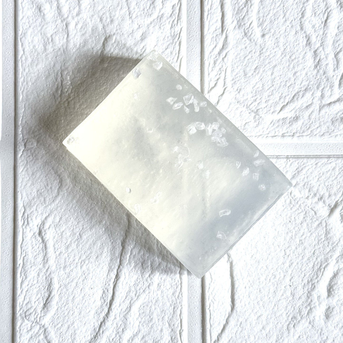 White rectangular soap with salt design on a textured white background